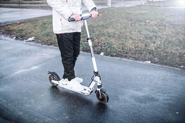 Riding an electric scooter in cold weather around the city