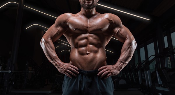 Image of a muscular guy with a naked torso and abs. Gym. Fitness concept