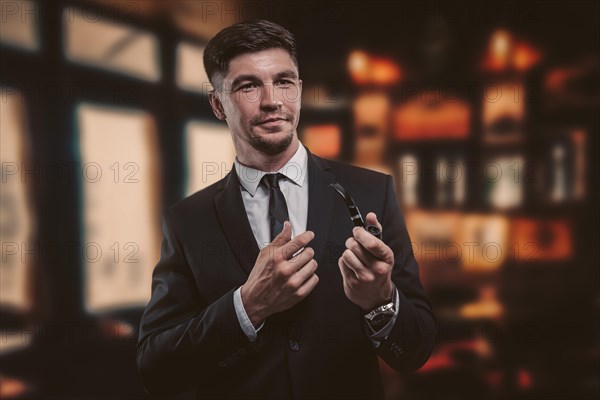 Portrait of an elegant man in a suit with a smoking pipe. Business concept.