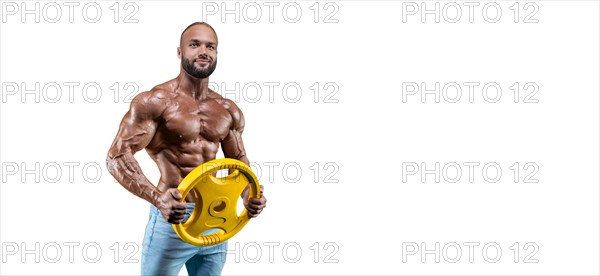 Sportsman posing on a white background in jeans with a dumbbell in his hand. Fitness