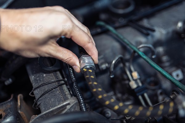 Auto mechanic regulates fuel supply with throttle cable lever