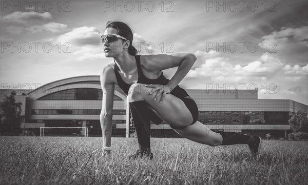 Image of a girl stretching on a soccer field. Sports concept.