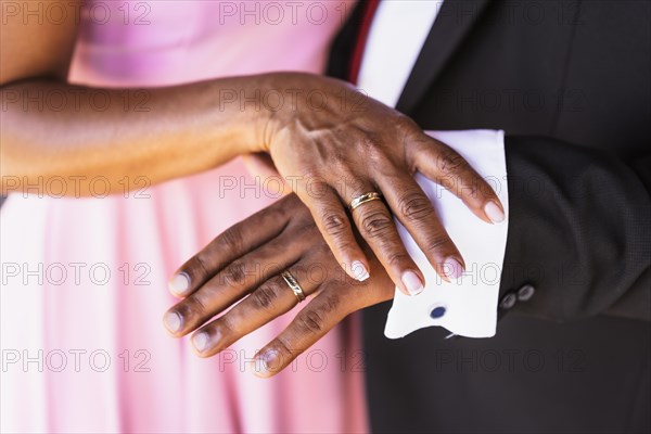 Black ethnic wedding couple showing rings at a wedding