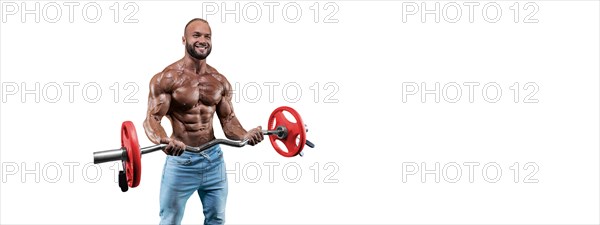 Athlete posing on a white background in jeans with a barbell in his hands. Fitness