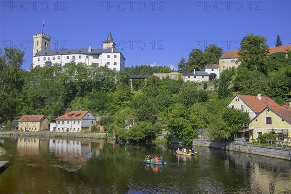 Rubber dinghies navigate the Vltava river behind the castle of