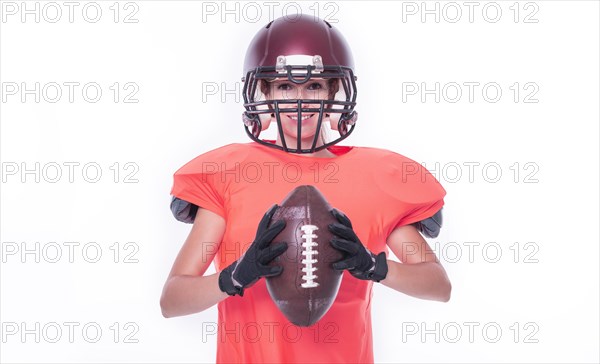 Woman in the uniform of an American football team player posing with a ball on a white background. Sports concept.