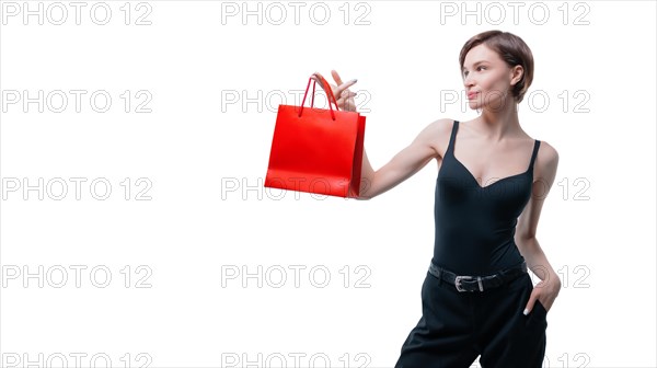 Portrait of stylish adult woman posing in studio on white background with red gift bag. Valentine's Day concept. Holidays and gifts