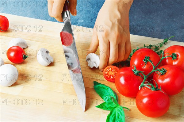 Professional chef cuts vegetables with a sharp knife from Damascus steel.