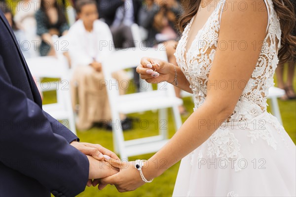 Bride about to put the ring on the groom at a beautiful wedding