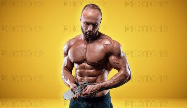 Isolated professional sportsman on a yellow background. Bodybuilding concept. Panorama. Advertising of a gym and sports nutrition.