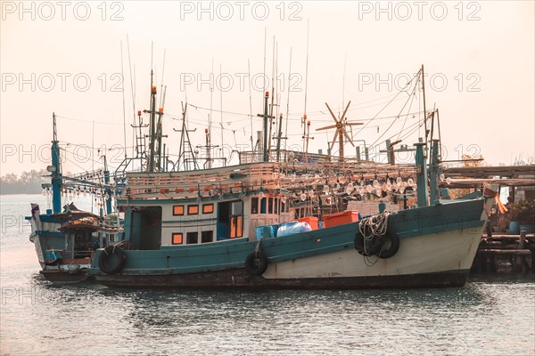 Old fishing boats with nets docked at a harbor
