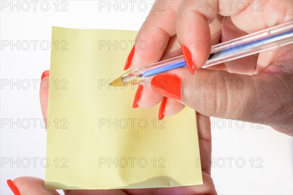 Woman's hand with painted nails holding blank letter paper on pure white background