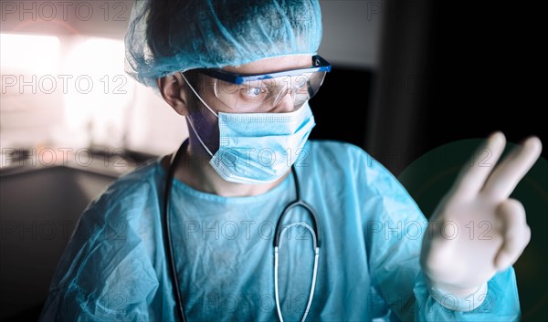 Male scientist doctor working in a laboratory with a monitor in a sterile uniform and glasses