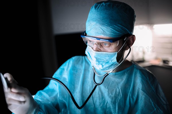 Doctor male surgeon in uniform working with a stethoscope in a medical office
