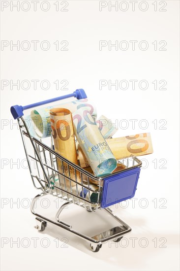 Shopping cart full of rolled up euro banknotes