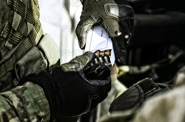 The fighter prepares a clip with bullets before the next fight.