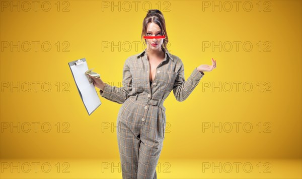 Charming woman in a suit stands in the studio on a yellow background. Coaching and mentoring concept.