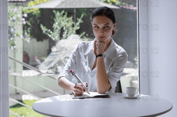 The girl writes in a notebook with a large pencil. Concept of job interview