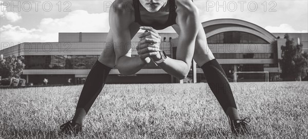 Beautiful young runner warms up on the soccer field before the race. Sports concept.