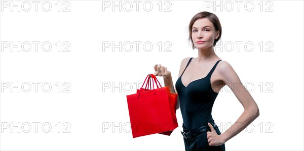 Beautiful young woman holding a craft red package in her hand. Shopaholics concept. Spenting. Gifts for the holidays. Black Friday. Shopping centers.