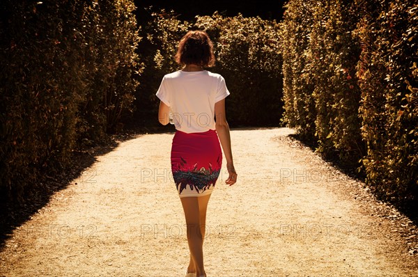 Portrait of a charming woman walking in the Boboli Gardens. Back view. Tourism and travel concept.