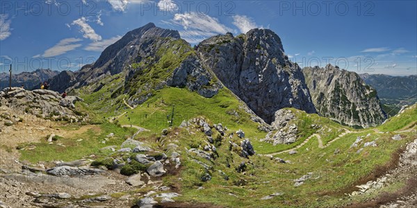 Panoramic view of a vast mountain landscape with green hills and blue sky