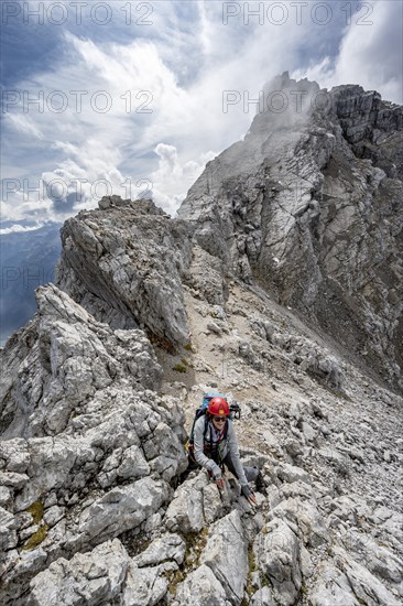 Mountaineer climbing on a narrow rocky ridge