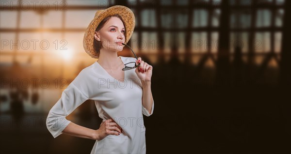 Portrait of a beautiful woman in a yellow hat standing at the airport with a passport and ticket. Travel concept.