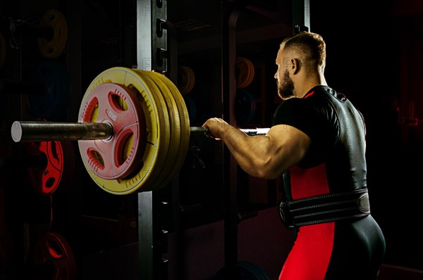 Professional athlete prepares to squat with a barbell.