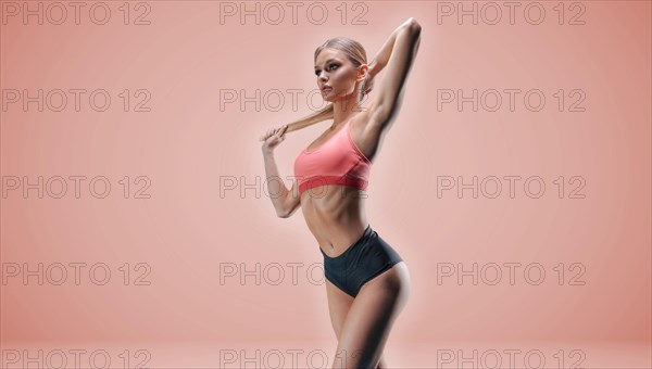 Charming tall girl posing in sportswear in the studio on a pink background. The concept of a beautiful figure
