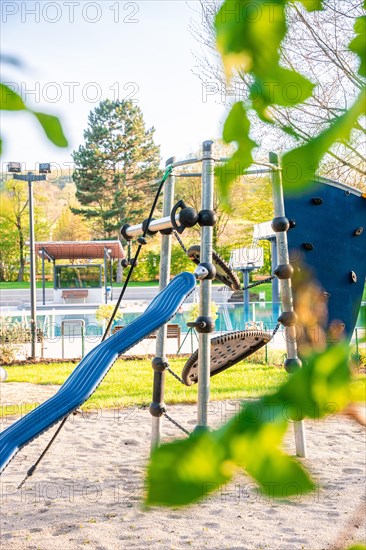 Colourful climbing frame with slide on a playground surrounded by nature