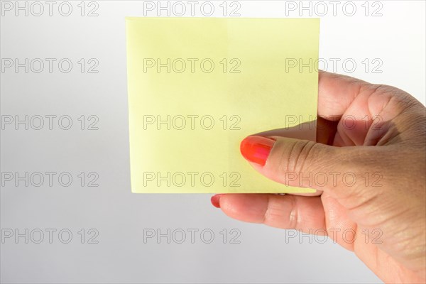 Woman's hand with painted nails holding blank letter paper on pure white background