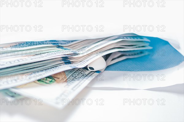 Pack of hundred-dollar bills along with a bug lie in an envelope. The concept of bribery and corruption.