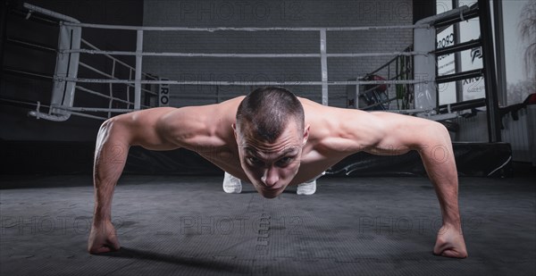 Muscular man doing push-ups in the gym. Fitness concept.