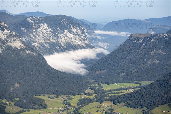 View of mountain valley with a few low-hanging clouds