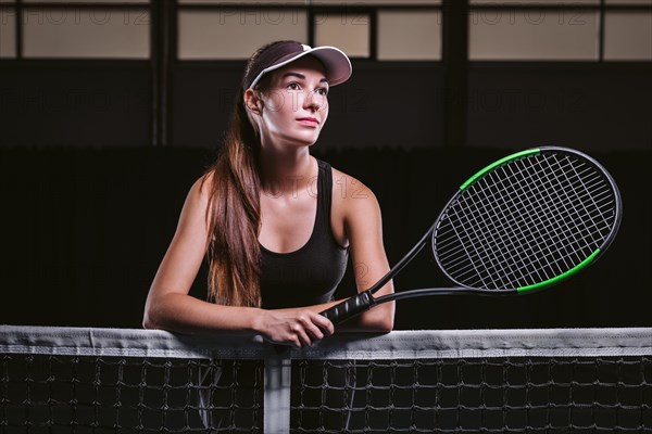 Portrait of a beautiful tennis player posing on the court. Sports concept.