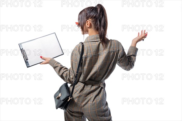 Portrait of a woman in a life style suit with a tablet and a white sheet in her hand. Back view. Business concept.