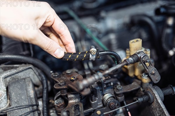 Auto mechanic regulates fuel supply with throttle cable lever