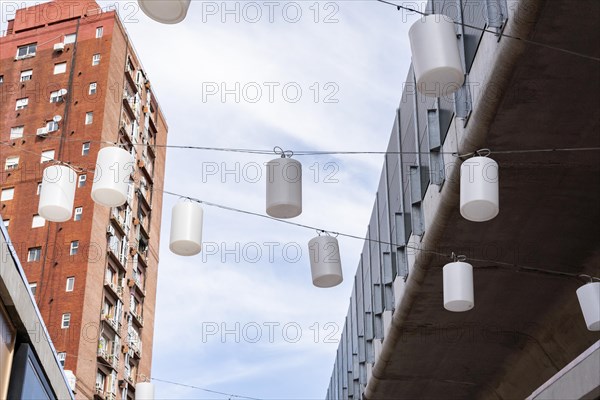 A view looking up at a pattern of hanging white chinese lanterns