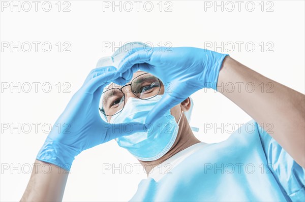 Portrait of a doctor on a white background. He made a heart out of his hands. Medicine concept.