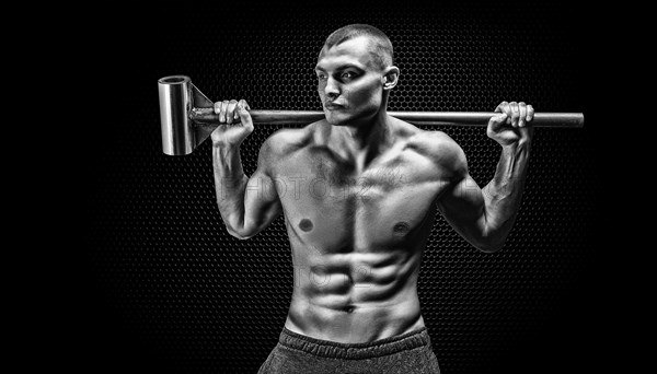 Portrait of an athlete with a sledgehammer on his shoulders. The concept of sport and healthy lifestyle.