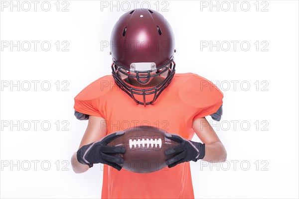 Woman in the uniform of an American football team player posing with a ball on a white background. Sports concept.