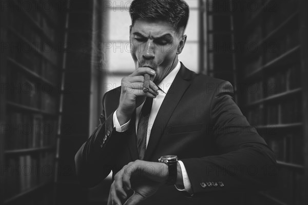 Portrait of a stylish man in a suit with a cigar. Business concept.