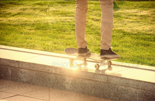 Desperate skateboarder performs dangerous movement on the skateboard at sunset