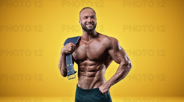 Isolated professional sportsman on a yellow background. Bodybuilding concept. Panorama. Advertising of a gym and sports nutrition.