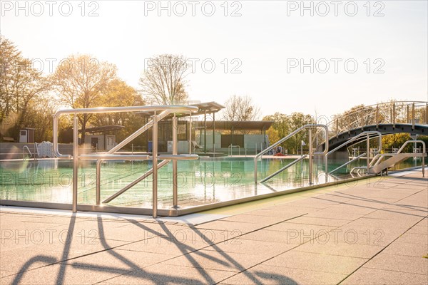 Outdoor swimming pool at sunset with clear water and railings