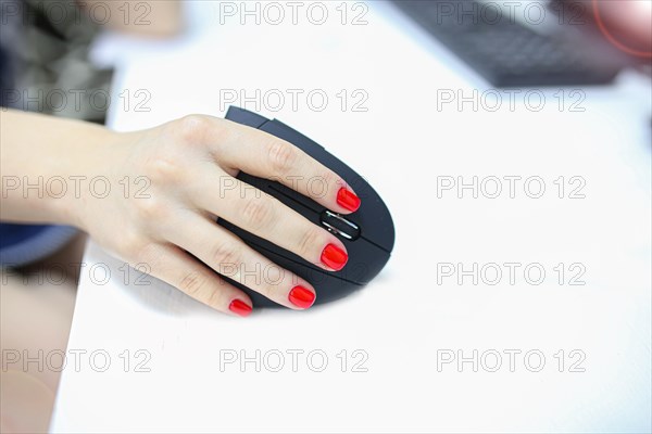 Girl's hand uses a vertical ergonomic joystick of a computer mouse. working at the computer