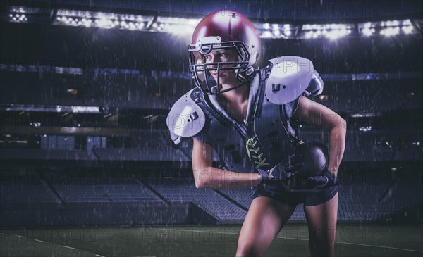 Image of a girl running with the ball across the stadium in the uniform of an American football team player. Sports concept.