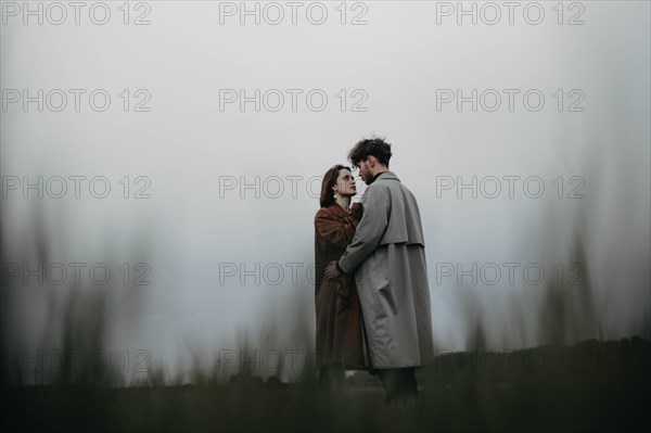 Couple in love in a foggy field. Relationship crisis and dramatic love concept