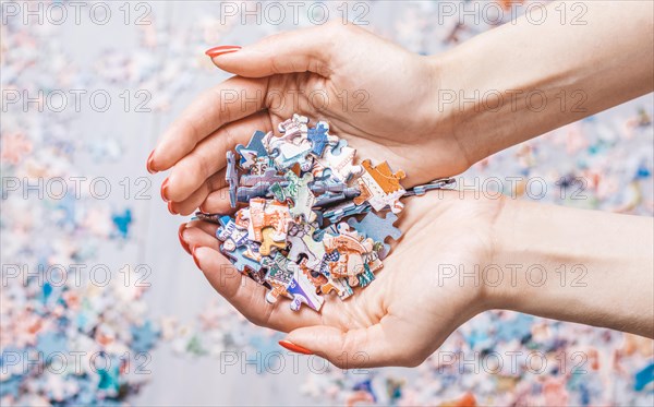 Woman holds a pile of puzzles in her hands. The concept of board educational games. Stay at home.